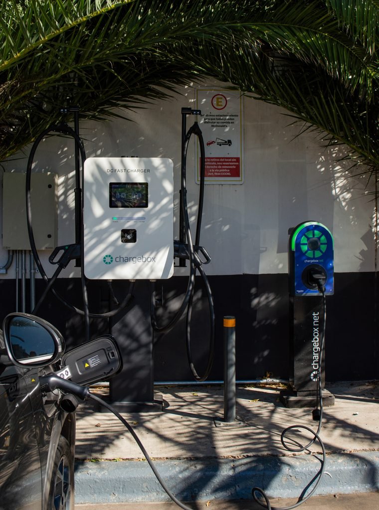 Cargadores Chargebox de pared y de pie en un punto de carga, con un auto eléctrico conectado